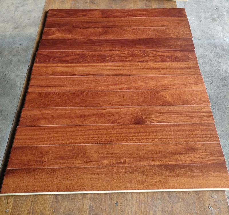 Sàn gỗ kỹ thuật Căm Xe với bề mặt đỏ nâu sang trọng, vân gỗ tự nhiên nổi bật, thi công hoàn thiện trong không gian hiện đại.