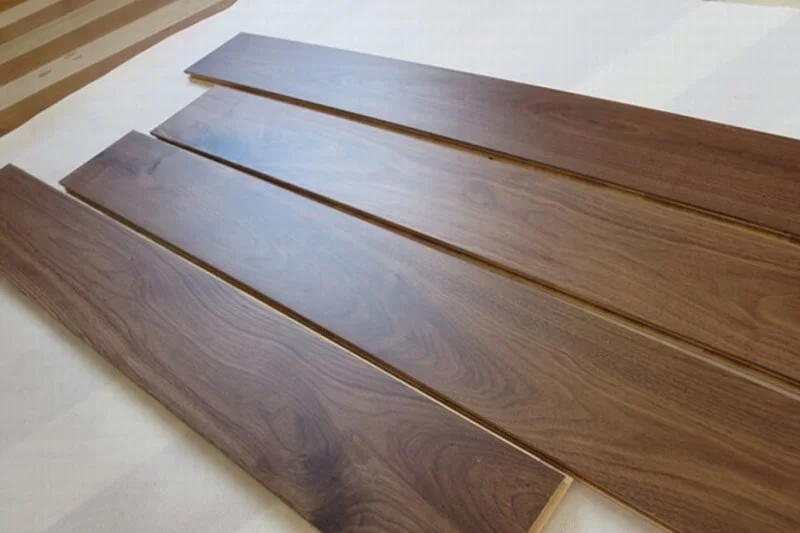 Cận cảnh vân gỗ óc chó tự nhiên trên bề mặt sàn kỹ thuật với sắc nâu đặc trưng và độ bóng mịn tinh tế.