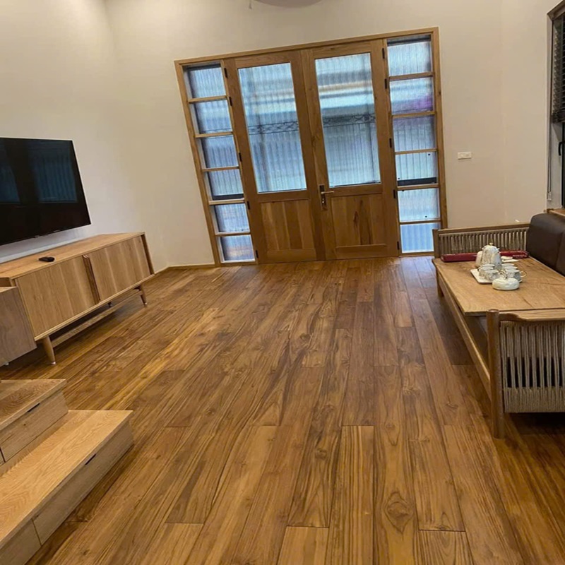Sàn gỗ Teak kỹ thuật lắp đặt trong phòng khách hiện đại, màu vàng nâu ấm, bề mặt phủ dầu tự nhiên sang trọng.
